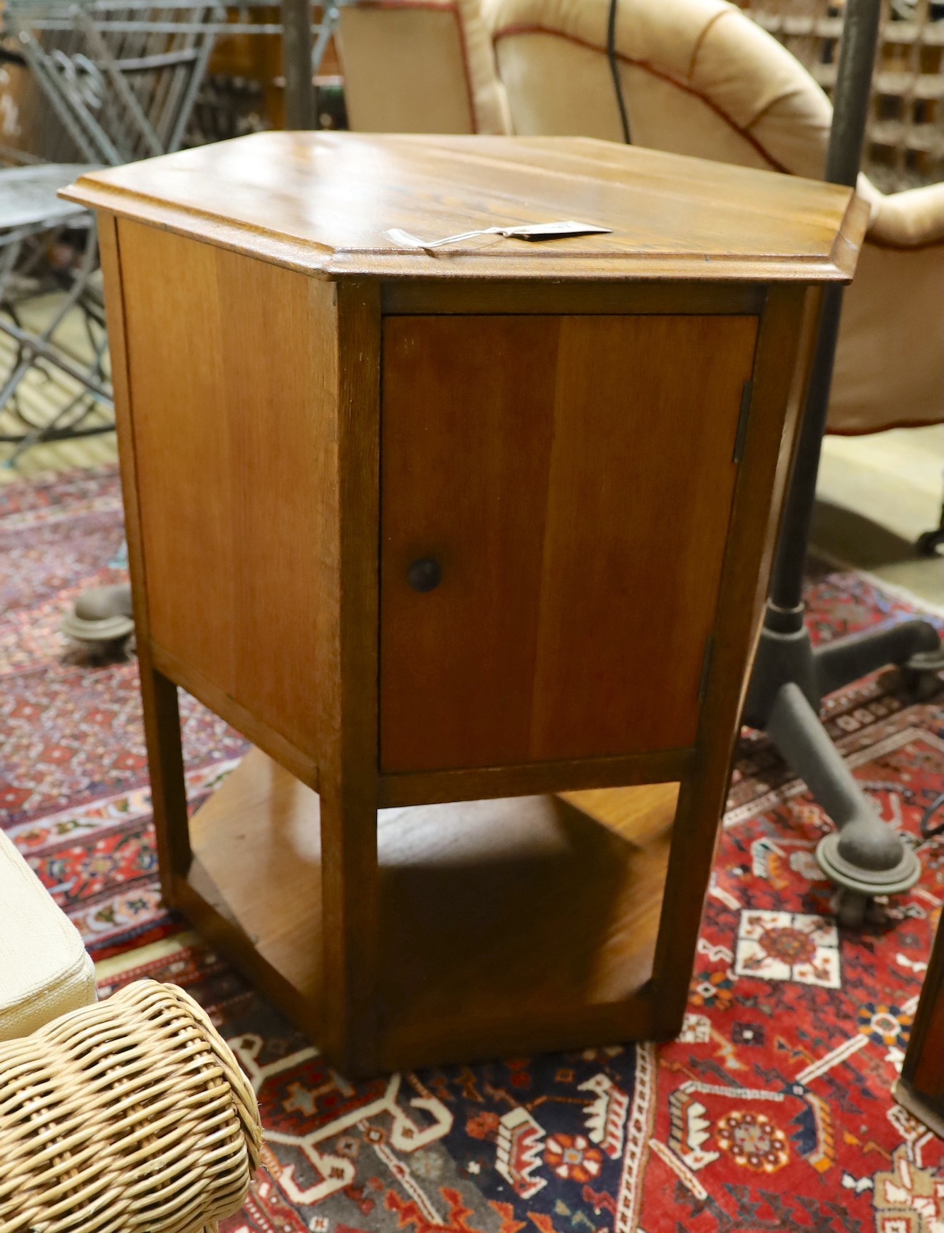 A mid 20th century hexagonal oak revolving cabinet, width 53cm, height 53cm